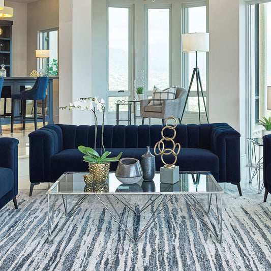 Sofá capitoné con brazos tipo esmoquin tapizado en azul