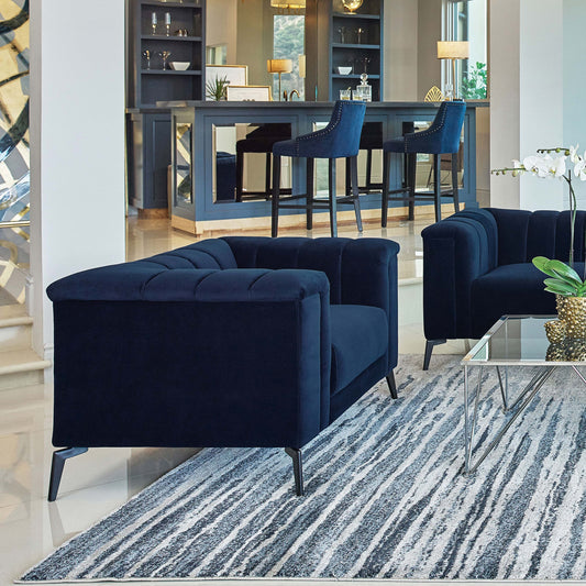 Sillón capitoné con brazos de esmoquin tapizados en azul