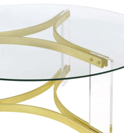 Mesa de centro Janessa redonda con tapa de vidrio y patas acrílicas, latón mate