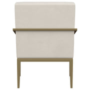 Sillón Kirra con brazos de metal tapizados en color crema