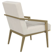 Sillón Kirra con brazos de metal tapizados en color crema